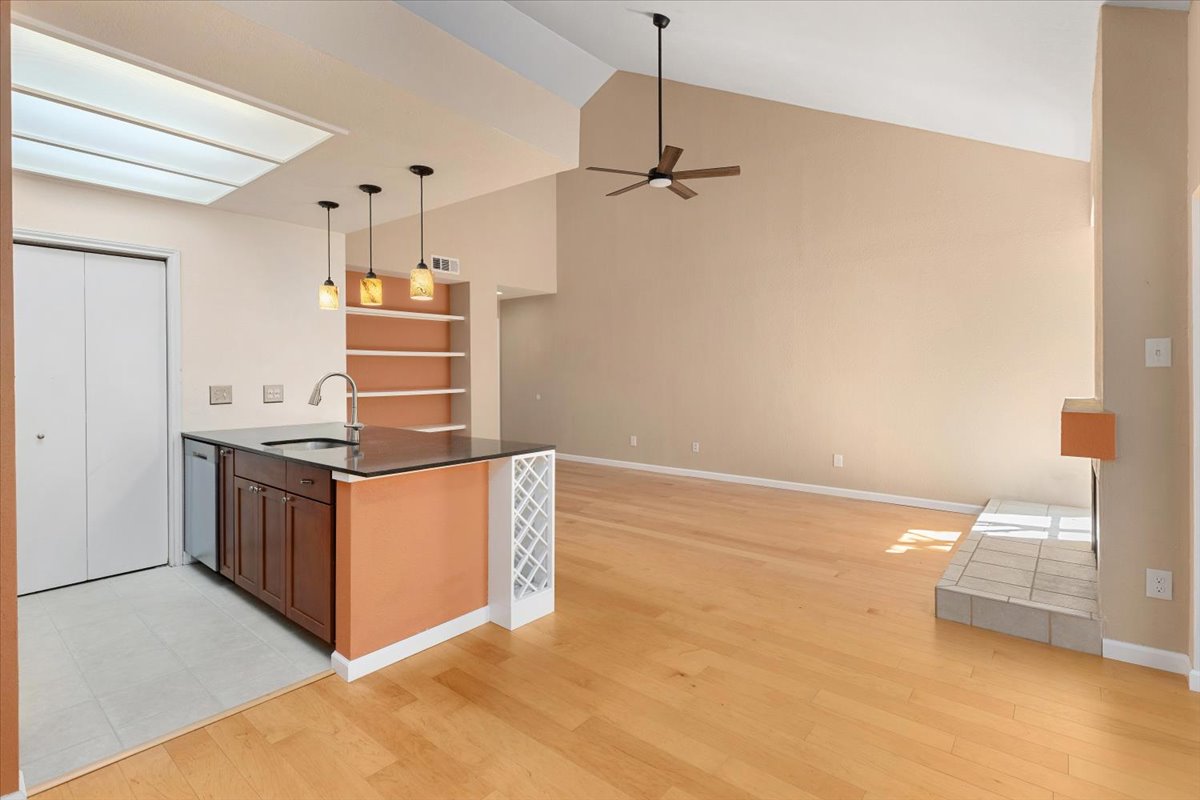 4711 Spicewood Springs Road, Unit 4222 Austin, TX 78759 - Photo 15 of 35 Natural light illuminates this open-concept living area, showcasing a modern kitchen island and inviting fireplace.