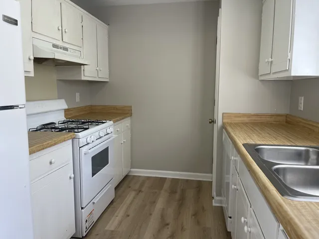 a kitchen with granite countertop white cabinets and white appliances