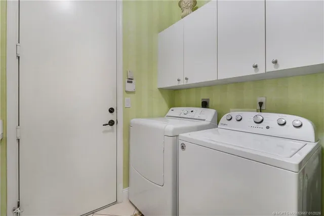 a view of a house with a swimming pool and a lawn chair under palm trees