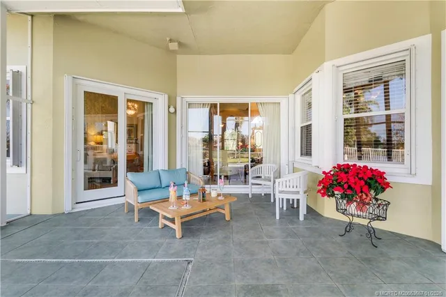 a spacious bedroom with a bed a chandelier and large mirror