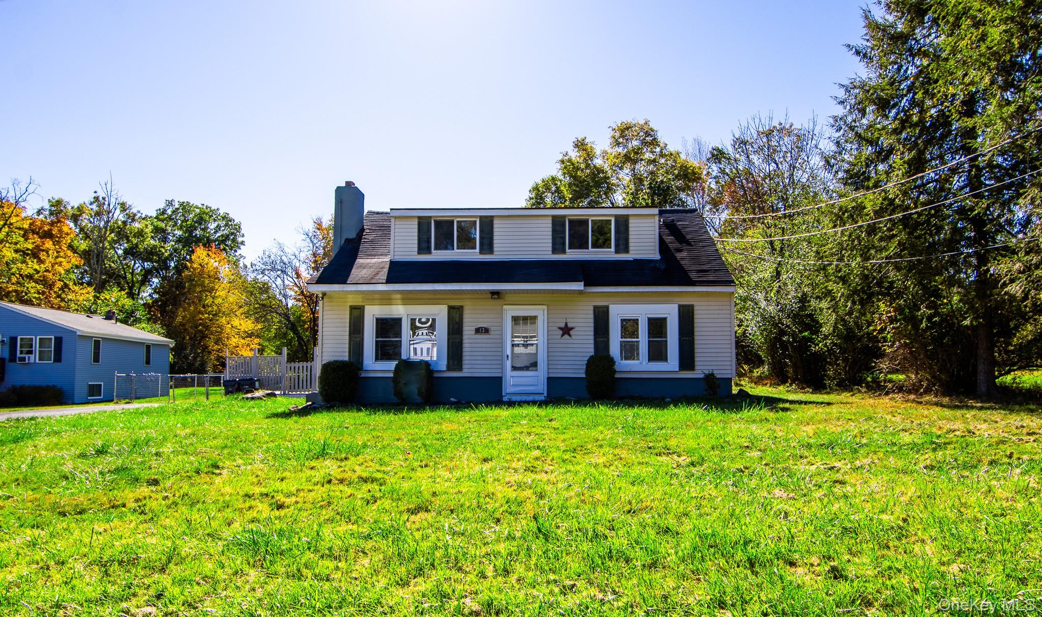a view of a house with a big yard potted plants and large tree