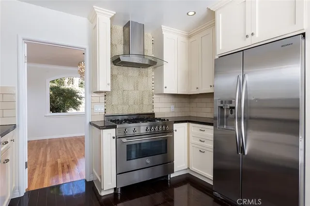 a kitchen with granite countertop white cabinets and stainless steel appliances