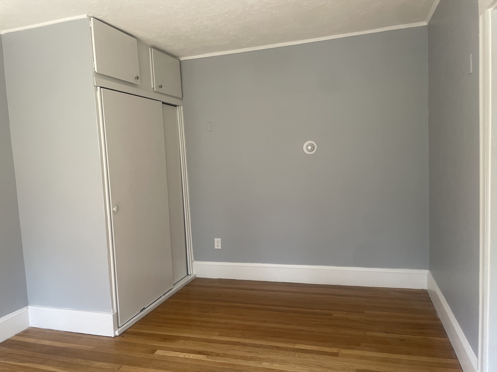21 Arbor Lane, Unit 21 Dedham, MA 02026 - Photo 6 of 10 a view of an empty room with wooden floor