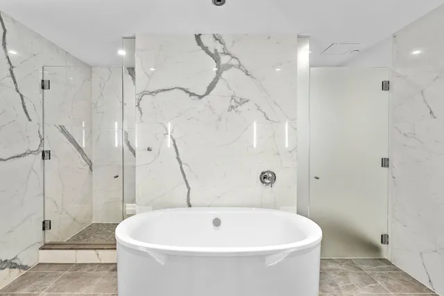a white bath tub sitting next to a white shower and a sink