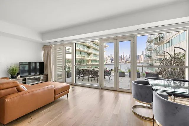 a living room with furniture a flat screen tv and a floor to ceiling window