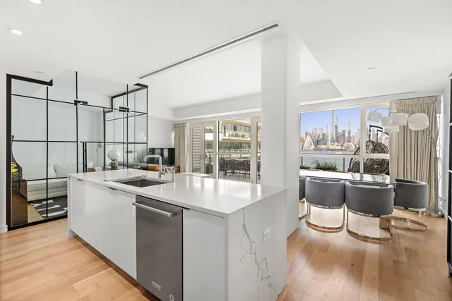 a large white kitchen with a large window and stainless steel appliances