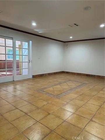 an empty room with a wooden floor and fan