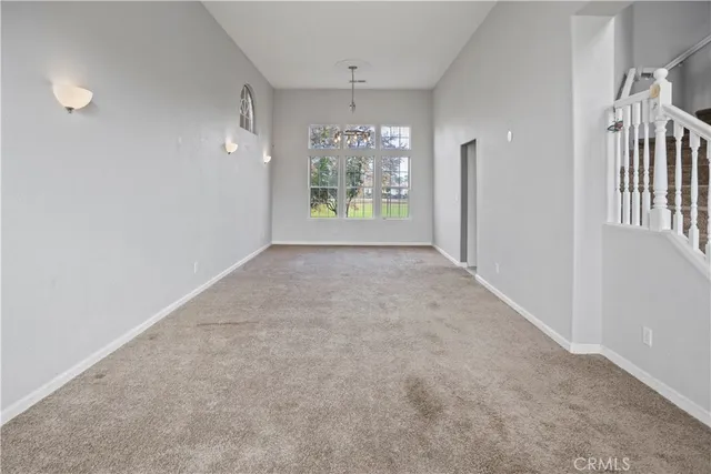 en empty room with windows and chandelier