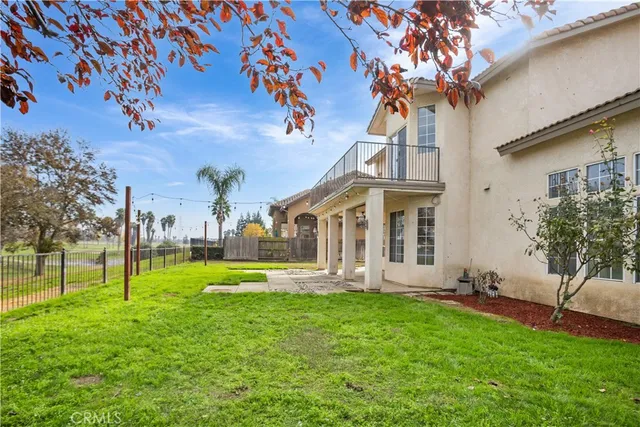 a view of a house with a big yard plants and large trees