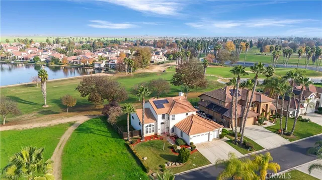 an aerial view of residential houses with outdoor space and lake view