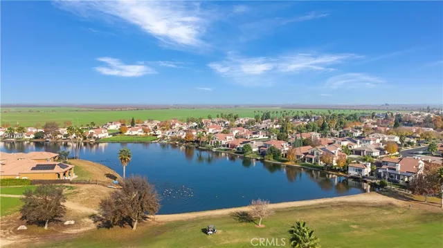 an aerial view of ocean and residential houses with outdoor space