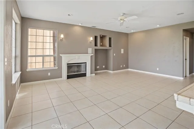 a view of an empty room with a fireplace and a window