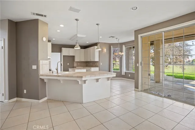 a large white kitchen with a refrigerator a sink and a cabinets