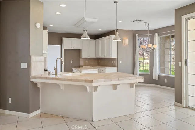 a kitchen with a sink a counter top space cabinets and stainless steel appliances