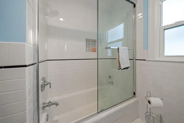 a bathroom with a granite countertop sink a mirror and shower