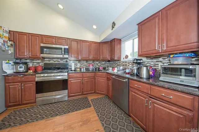 a kitchen with granite countertop wooden cabinets and stainless steel appliances