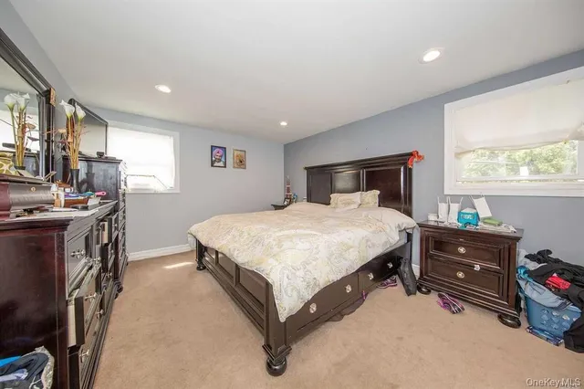 a bedroom with a bed dresser and a window