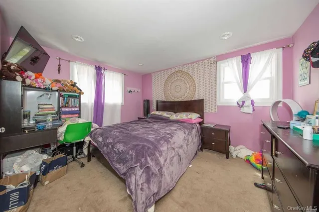 a bed room with a bed mirror and a window