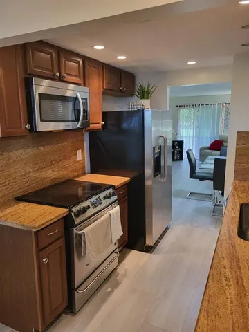 a kitchen with stainless steel appliances granite countertop a stove a microwave and a refrigerator
