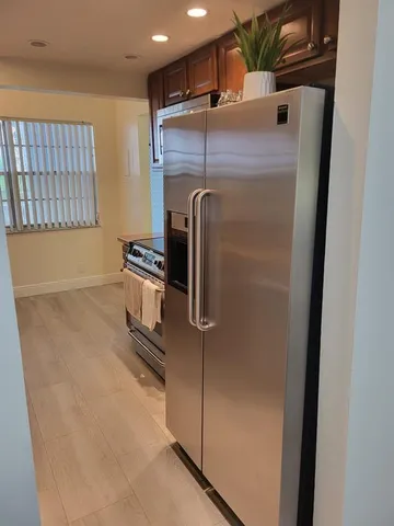 a close view of a refrigerator in kitchen and a window
