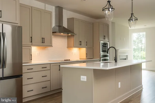 a kitchen with stainless steel appliances a sink a stove and a refrigerator