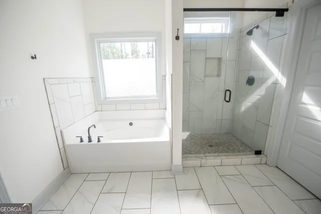 a bathroom with a bathtub a shower and a mirror