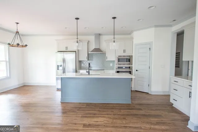 a view of kitchen with stainless steel appliances granite countertop cabinets a sink a center island and a window