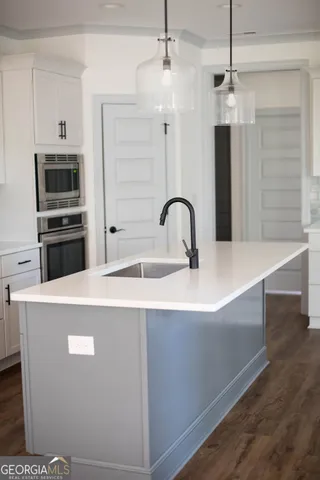 a kitchen with stainless steel appliances a refrigerator sink and wooden floor