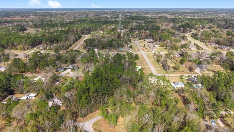 an aerial view of residential houses with outdoor space and trees