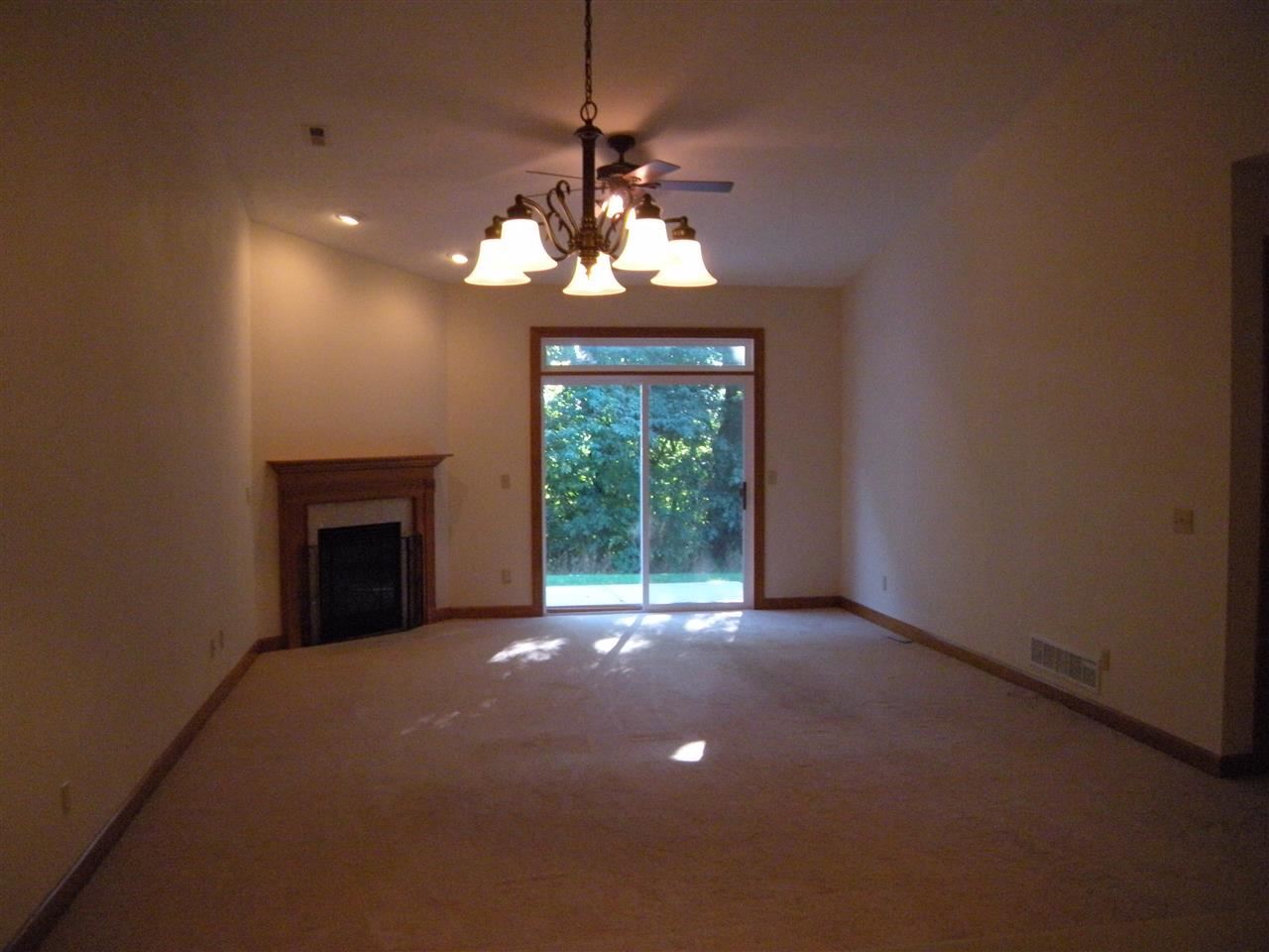 10337 Marblewing Road Roscoe, IL 61073 - Photo 10 of 14 a view of an empty room with a fireplace and a window