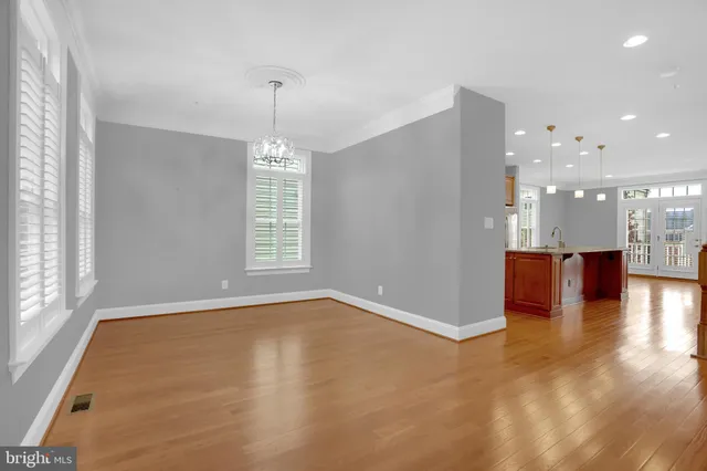 an empty room with windows and ceiling fan