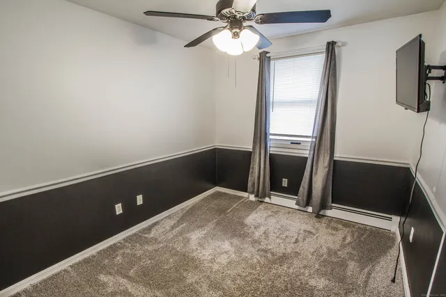 an empty room with windows and fan