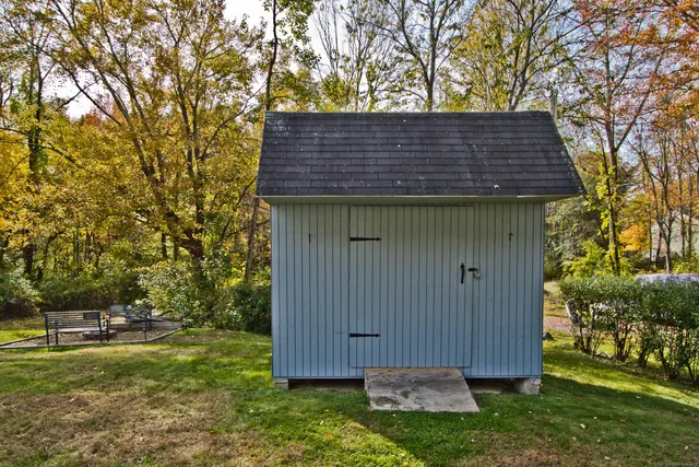 a backyard of a house with wooden fence and large trees