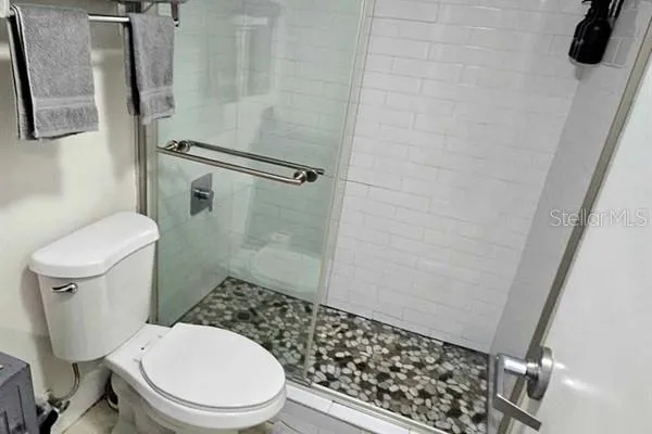 a white toilet sitting next to a shower