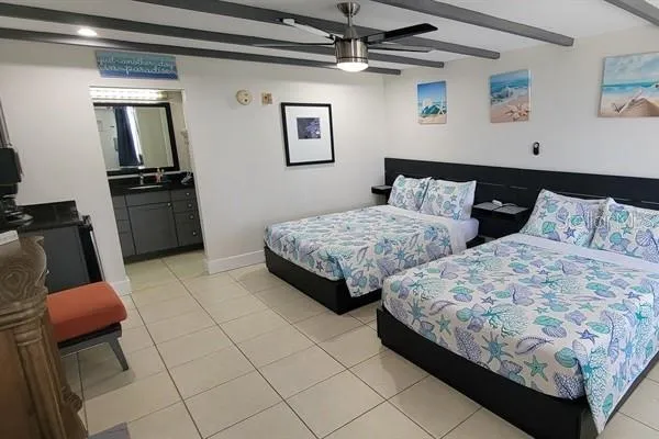 a bedroom with two beds and a mirror