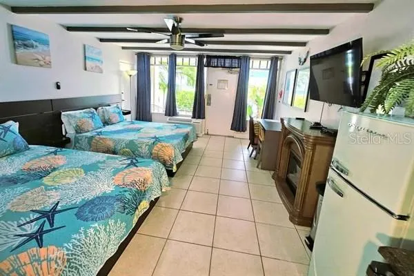 a bedroom with a bed a fireplace and a flat screen tv