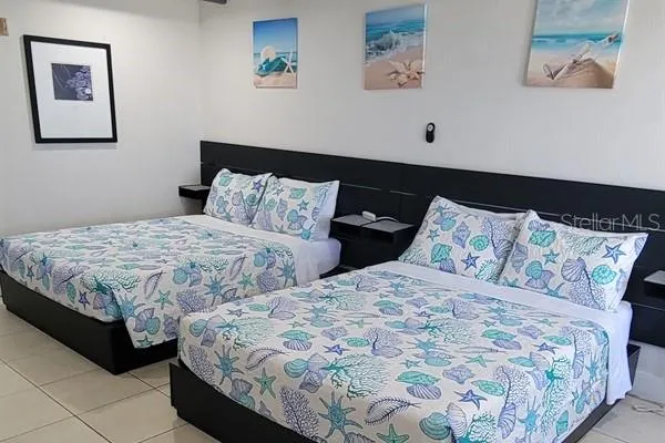 a bedroom with two beds and painting on the wall