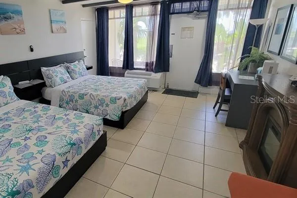 a bedroom with two beds and a large window