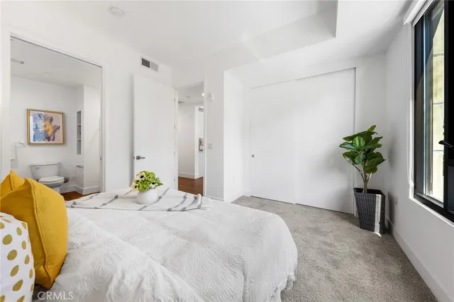 a bedroom with a bed and a potted plant