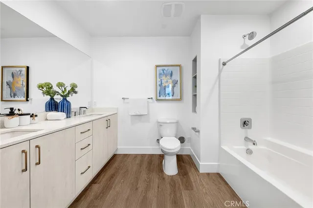 a bathroom with a granite countertop sink toilet a large mirror a shower and a bathtub