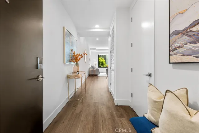 a view of a hallway with wooden floor and furniture