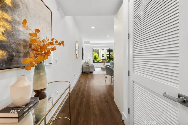a view of a hallway with wooden floor and a potted plant
