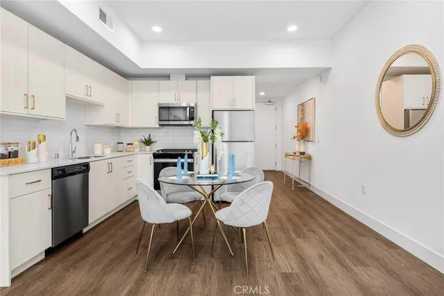 a kitchen with a dining table chairs and white cabinets