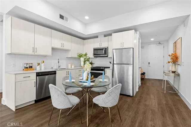 a kitchen with refrigerator cabinets dining table and chairs
