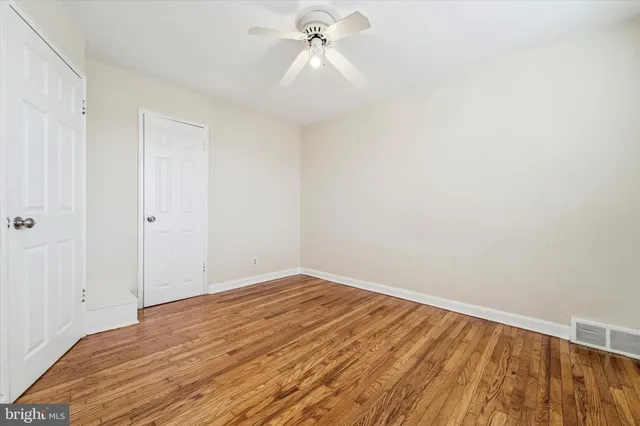 a view of a room with wooden floor and a ceiling fan