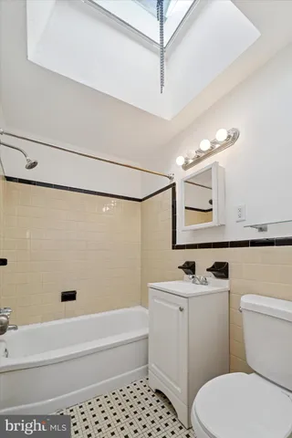 a bathroom with a sink a toilet a mirror and shower