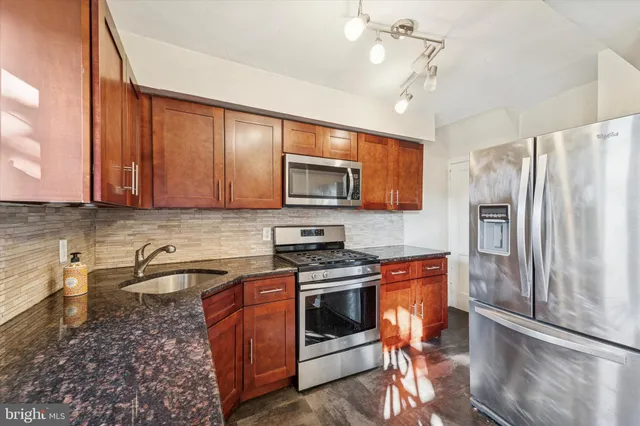 a kitchen with stainless steel appliances granite countertop a stove a refrigerator and a microwave