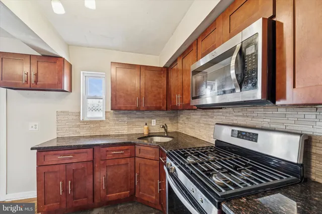 a kitchen with sink a stove and cabinets