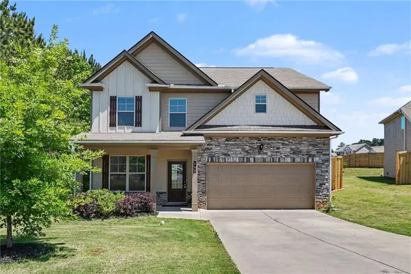 a front view of a house with a garden and yard