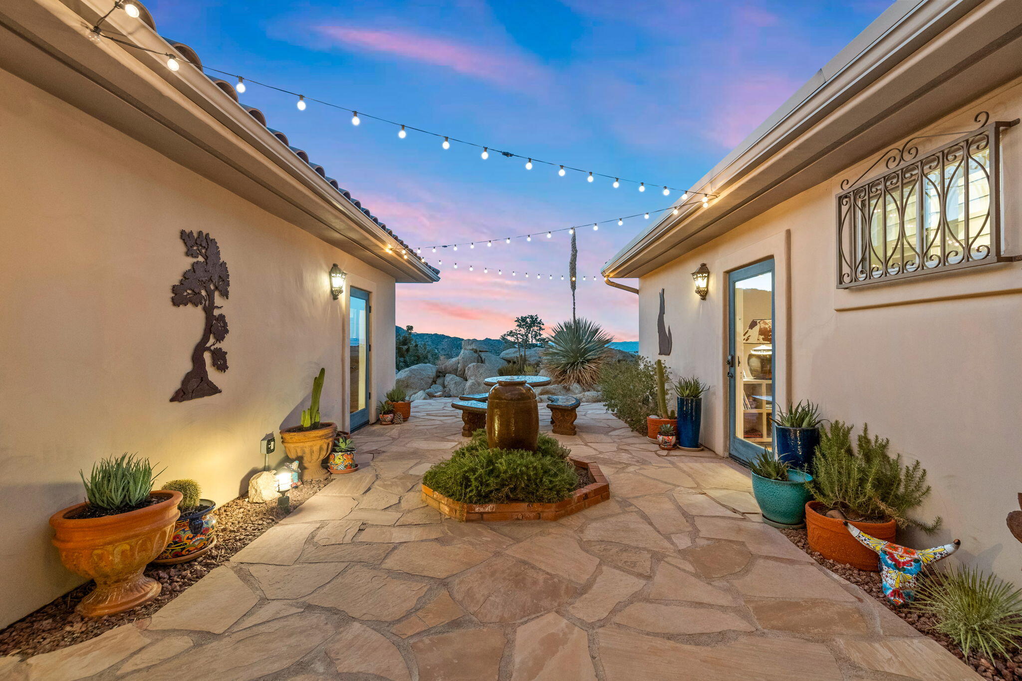 60150 Santa Rosa Road Mountain Center, CA 92561 - Photo 28 of 62 a view of a patio with couches chairs potted plants and floor to ceiling window